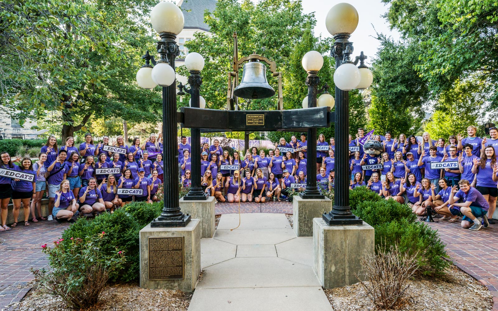 K-State College of Education students cheer while surrounding the Bluemont Bell