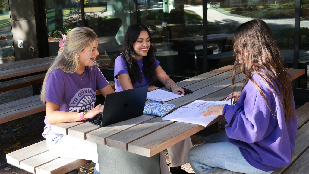 students sitting at a bench working 